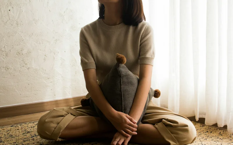 Person sitting on the floor at home in a quiet living room
